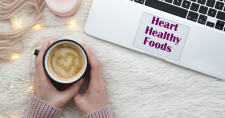 Heart Healthy Foods. Picture of a caucasian female's hands holding a cup of hot chocolate with a heart in the froth on top.