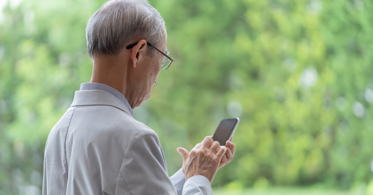 Elderly man on his cell phone, beware of senior scams.