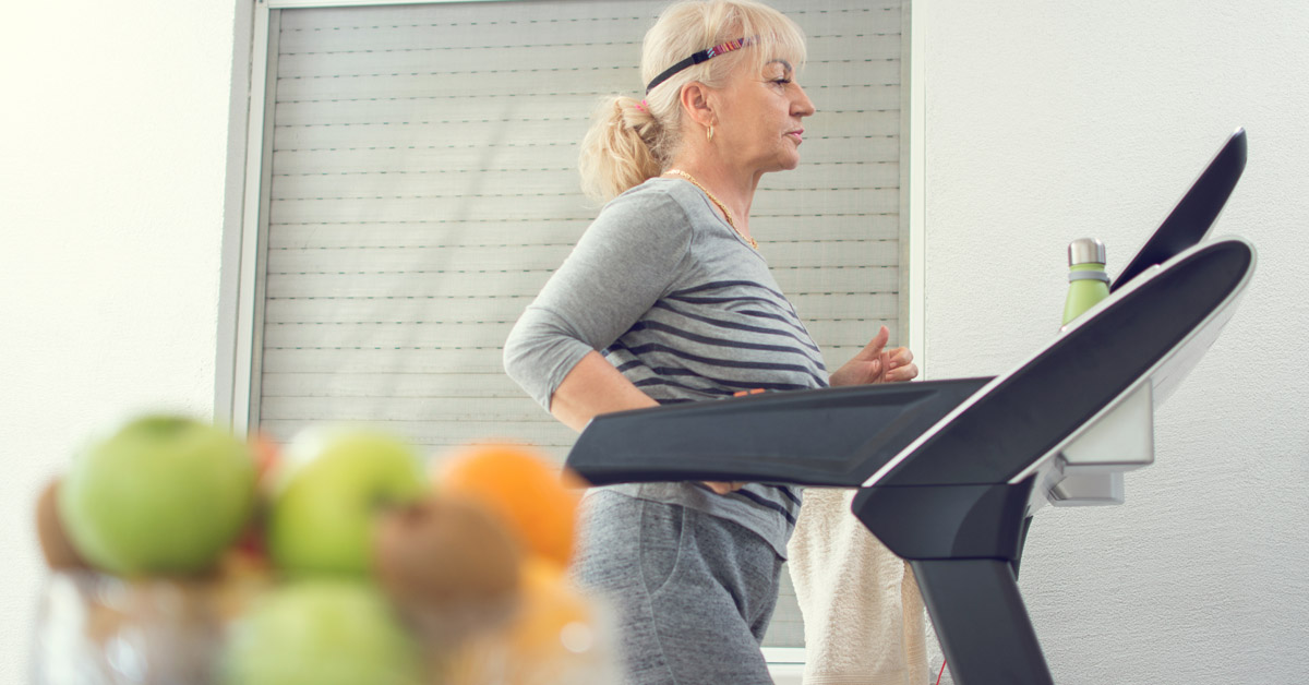 Elderly lady working out on the treadmill in her home.